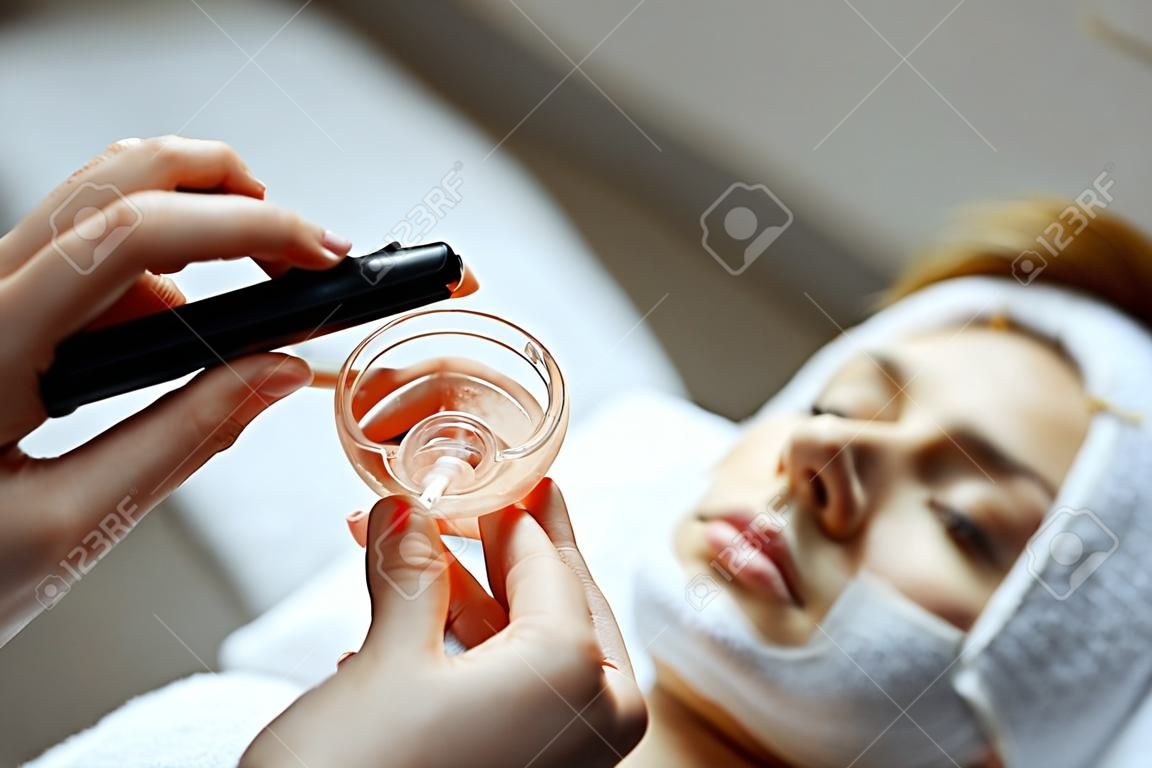 Mujer joven que tiene procedimiento de máscara en el centro de spa