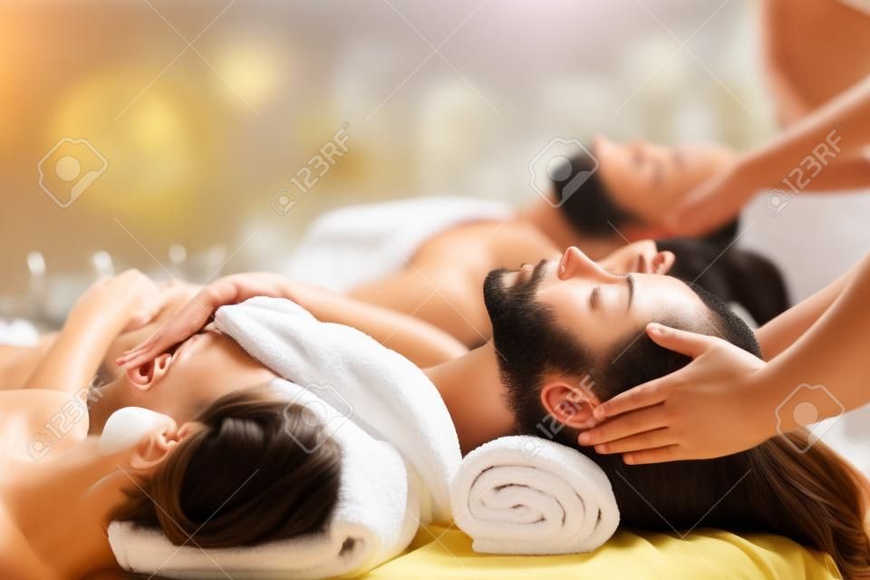 счастливая молодая красивая пара наслаждается массажем головы в спа-салоне