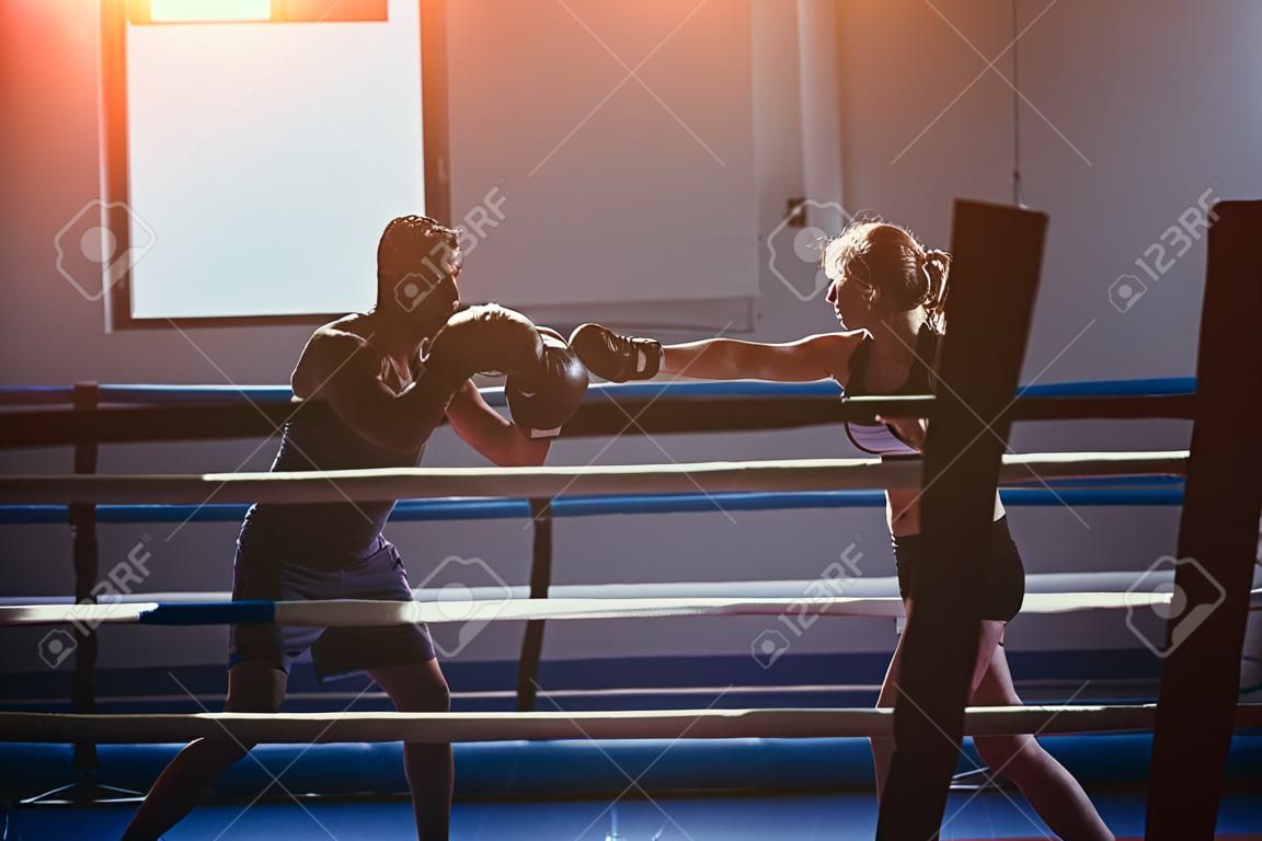 woman exercising with trainer at boxe and self defense lesson. Copy space