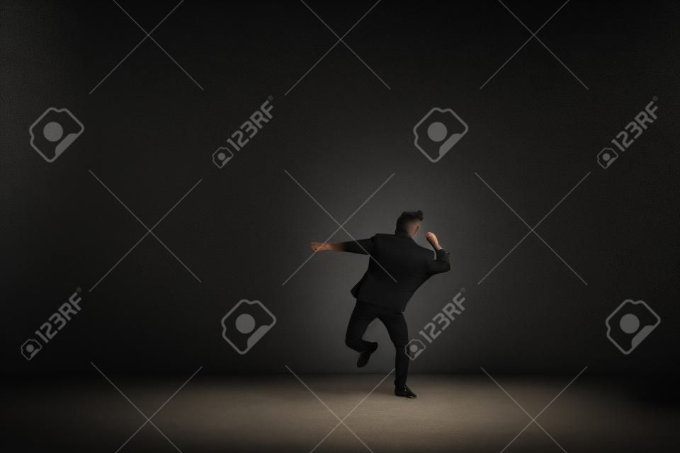 dancing pose of male on one leg on the dark background