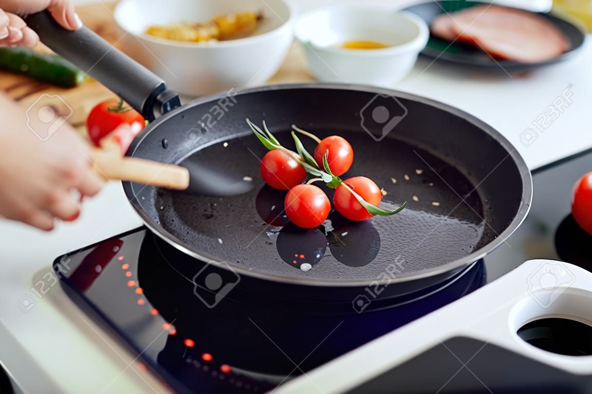 Closeup of woman roasting kebabs on frying pan