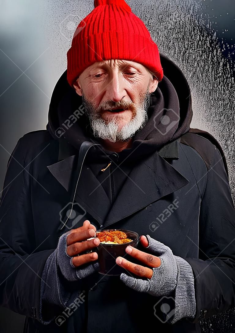 Beggar male cry about lack of food. Dream about shelter and food. Homeless man standing under rain, look at camera