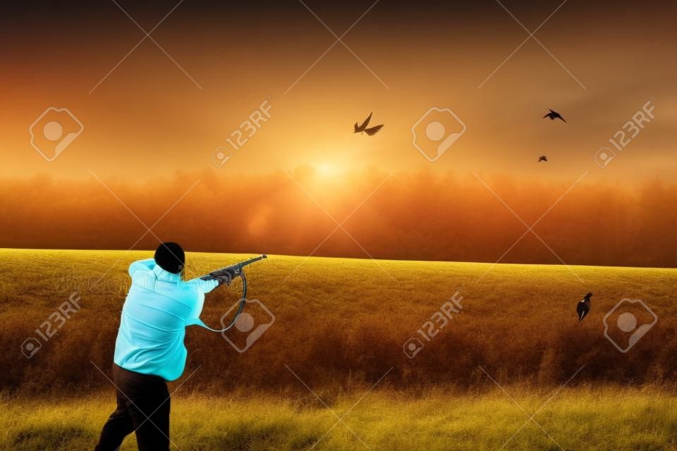 jonge man in specifieke kleding gericht op vliegende vogel tijdens de jacht. zijaanzicht foto. kopieer ruimte