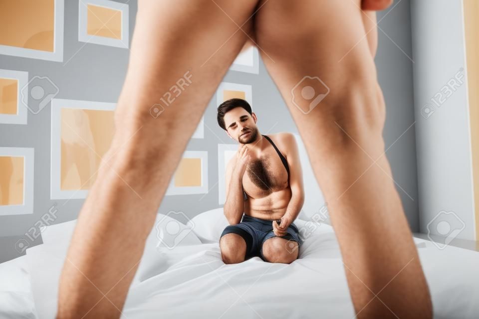 Embarrassed or confused young femake looking at male genital area feeling sorry with his disfunktion. Erectile dysfunction concept. Potency sexual problems and pornography concept.
