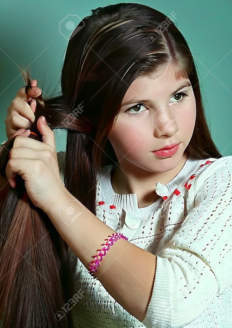 teen girl plaiting long brown thick hair