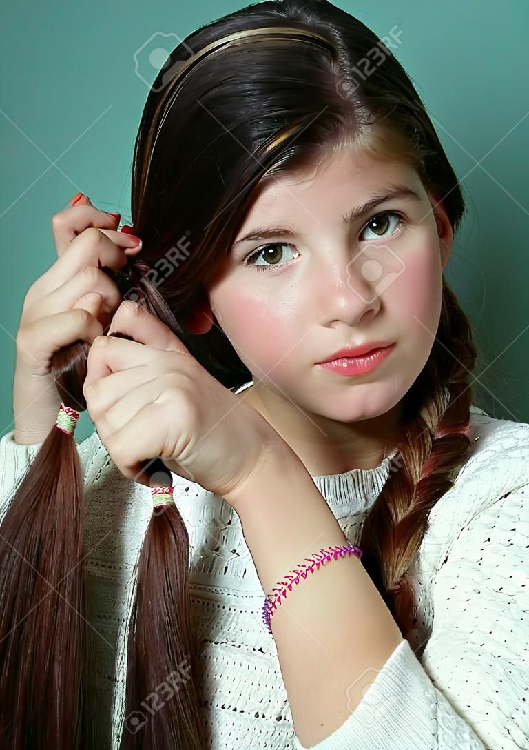 teen girl plaiting long brown thick hair