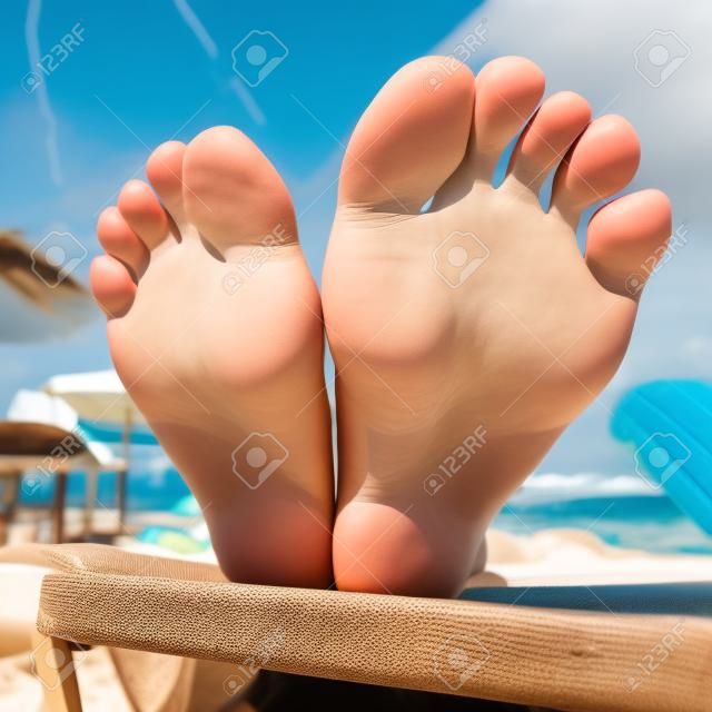 Wideangle closeup of a woman soles on a beach seat