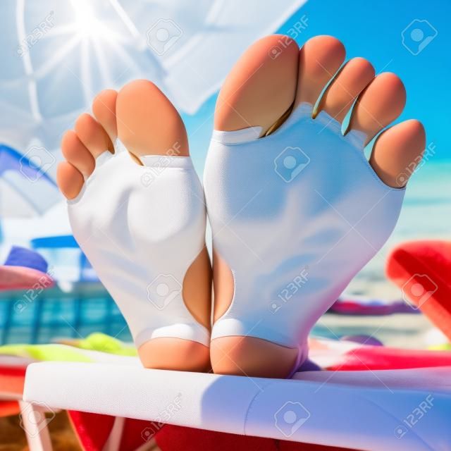 Wideangle closeup of a woman soles on a beach seat