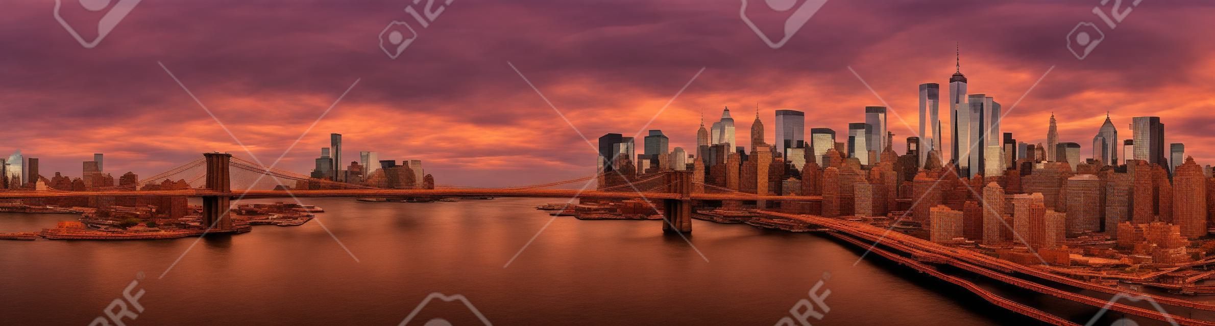 Puente de Brooklyn panorama al atardecer. El hito icónico extiende entre Brooklyn y el horizonte de Nueva York Distrito financiero, dominado por la Torre de la Libertad.