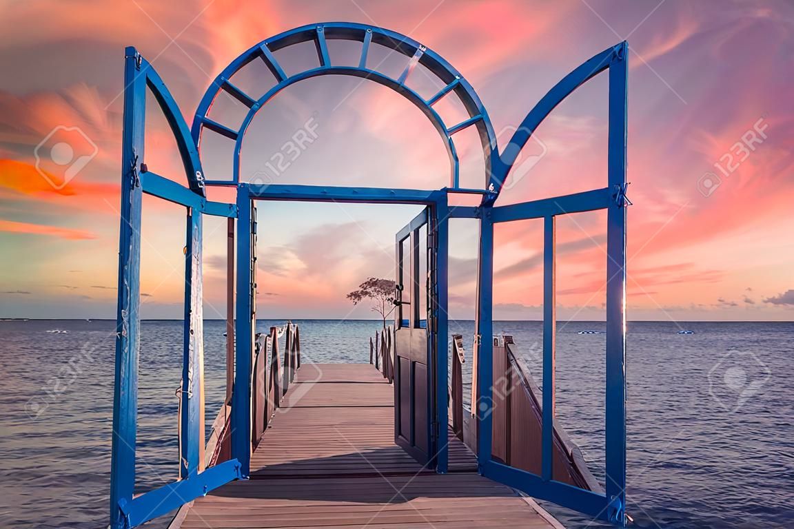 Niebieskie drzwi na morzu karaibskim na wyspie roatan o zachodzie słońca. Honduras