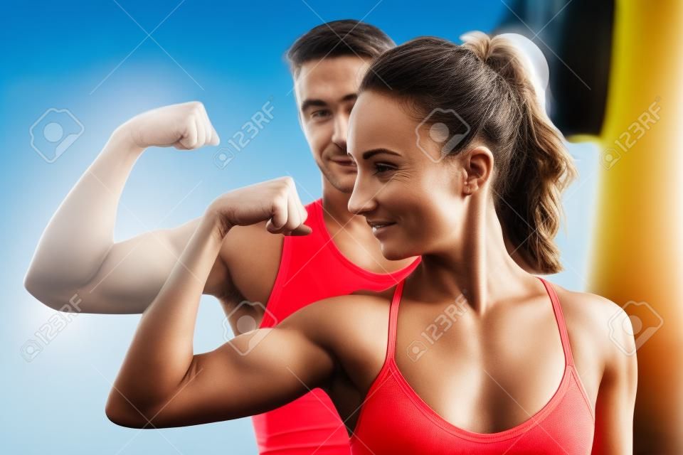 Active athletic sportive woman girl and man showing their muscles biceps healthy lifestyle.