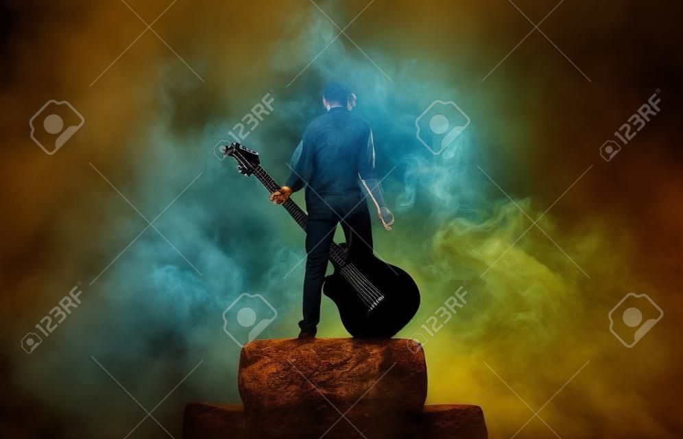 De muzikant speelt op een grote rock gitaar in een grote rook