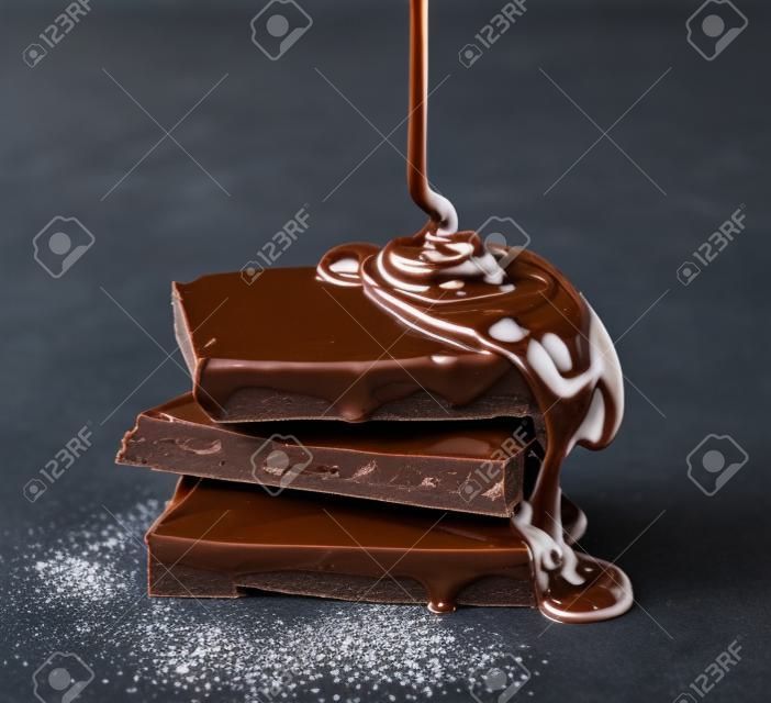 Topiony czekoladą wylewa się na stos mleka i ciemnej czekolady
