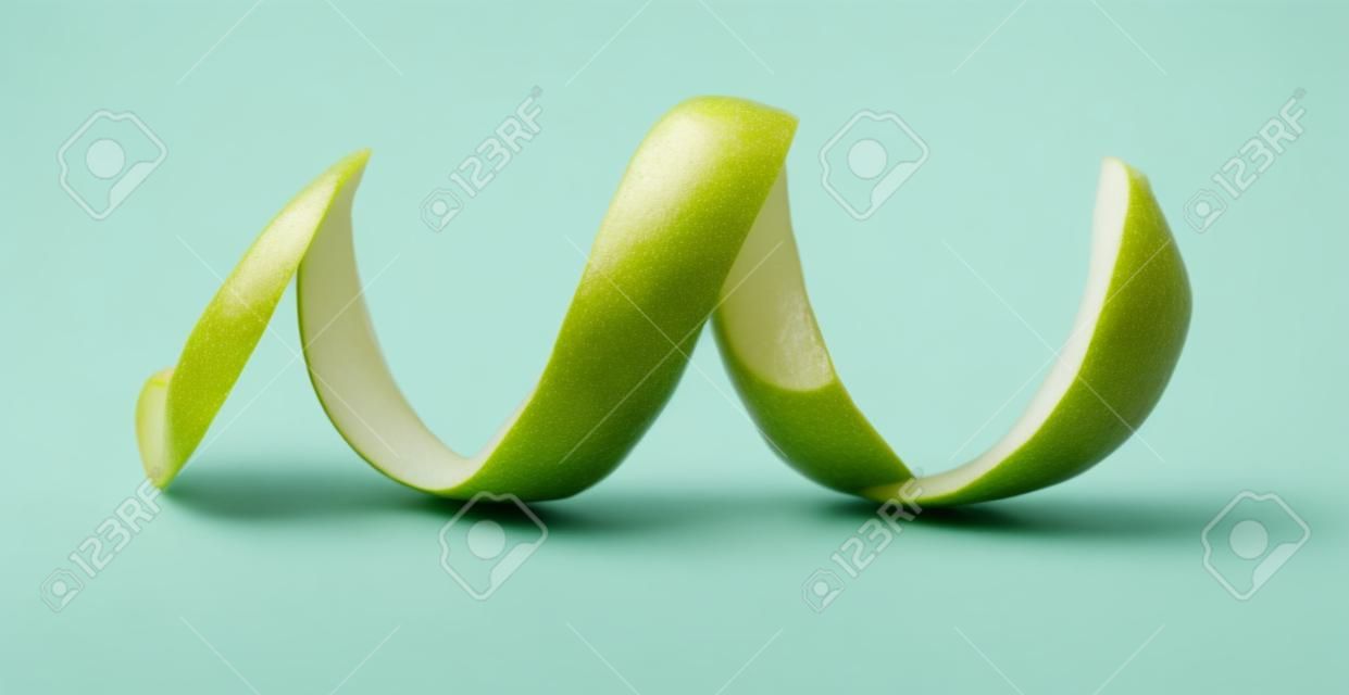 Peeling green apple on a white background