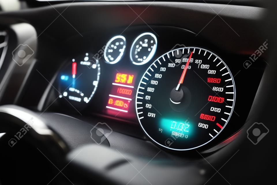 Close-up shot van een snelheidsmeter in een auto. Auto dashboard. Dashboard details met indicatie lampen. Auto instrumentenpaneel. Dashboard met snelheidsmeter, tachometer, odometer. Autodetaillering.