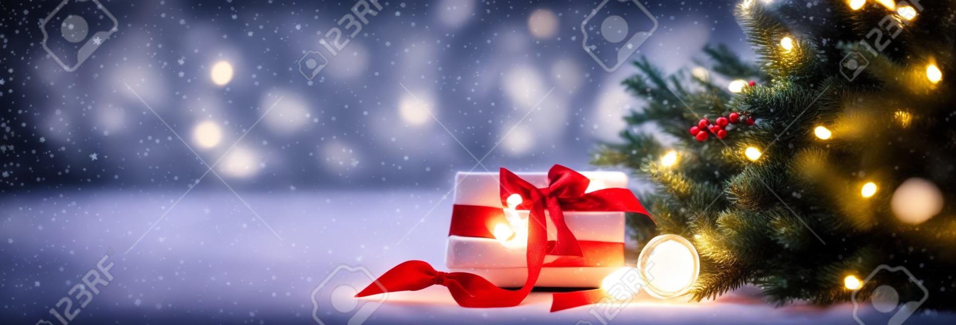 Weihnachtliche Gemütlichkeit in einem Raum auf hellem Hintergrund, mit Lichtern und Zweigen eines Weihnachtsbaums und einem Geschenk mit roter Schleife auf dem Tisch, Platz für Text