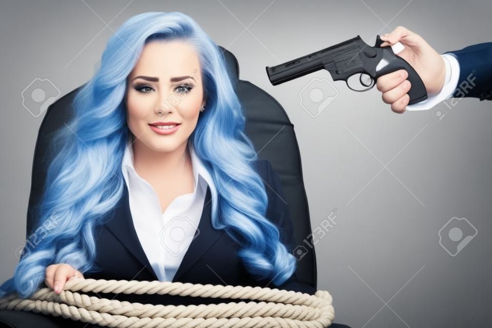 비즈니스 여자는 밧줄로 의자에 바인딩 및 흰색 배경에 고립 된 총을 머리에 목표