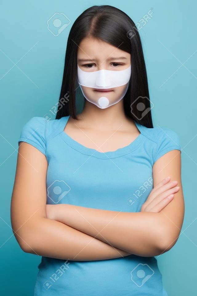 It is better to be silent. Upset girl with self-adhesive tape over her mouth