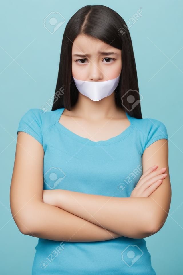 It is better to be silent. Upset girl with self-adhesive tape over her mouth