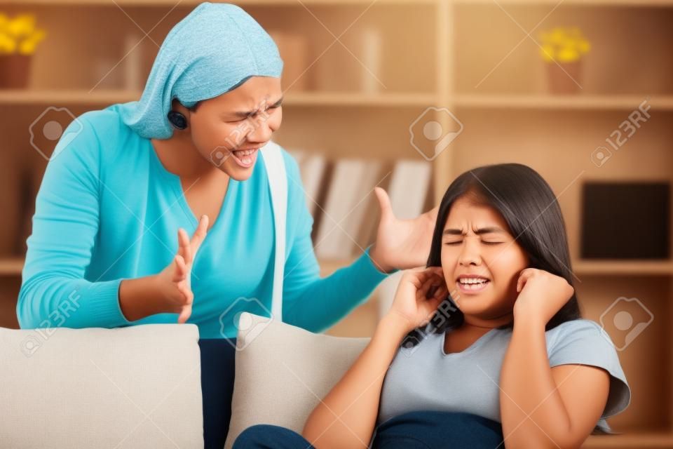 Concept de problèmes entre générations. Teen ferma les oreilles avec ses mains pendant que sa mère lui crie dessus.