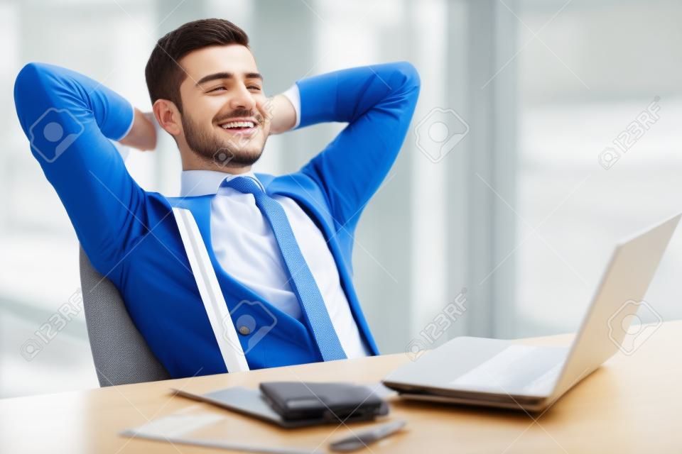 A time for relax. Young, happy businessman is relaxing in his office.