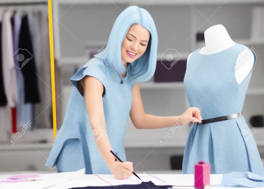 Vrouwelijke mode-ontwerper nemen meting en opschrijven.