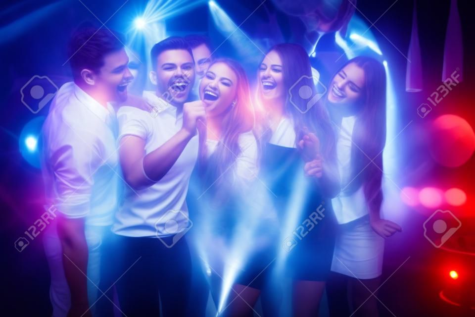 Young People. Dance Club. Sing. Men. White Shirt. Microphone. Trendy Modern Nightclub. Party Maker. Birthday. Karaoke Club. Celebration. Holidays Concept. Dancing People. Great Mood.