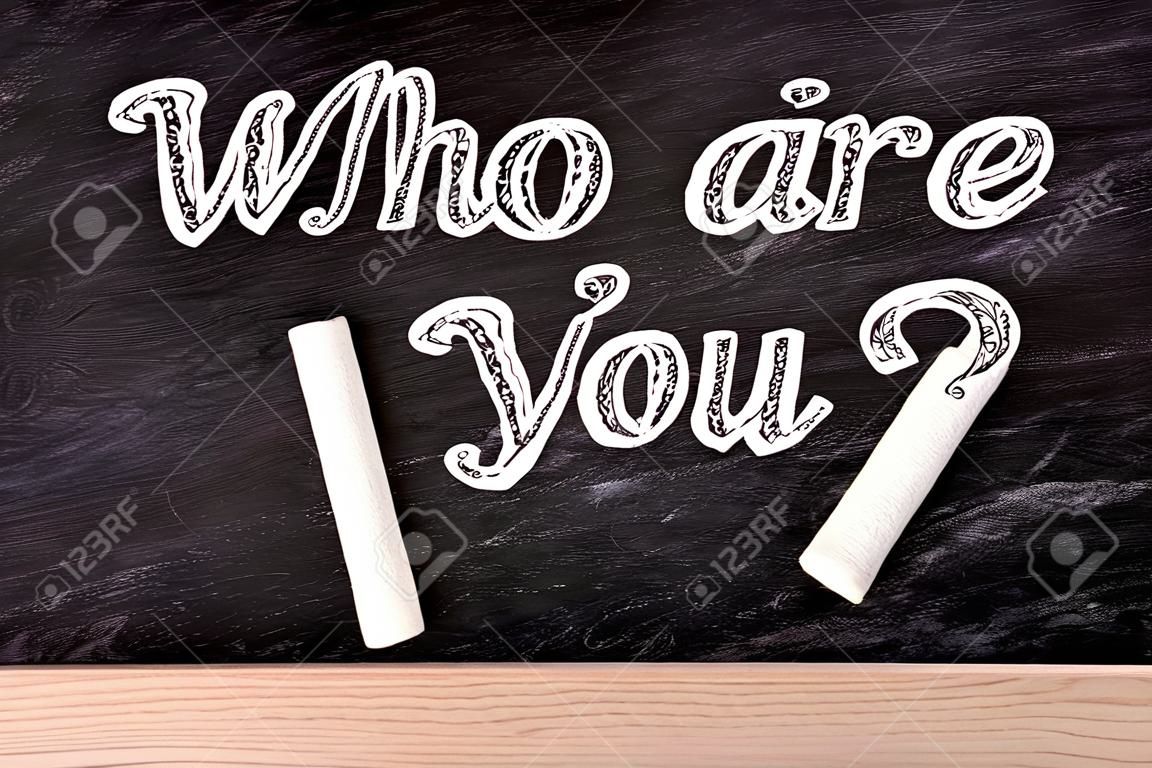 Who are you? text on blackboard with a piece of chalk.