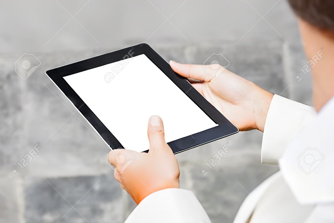 콘크리트 벽을 배경으로 한 사업가의 손에 흰색 화면이 있는 클로즈업 태블릿 모형