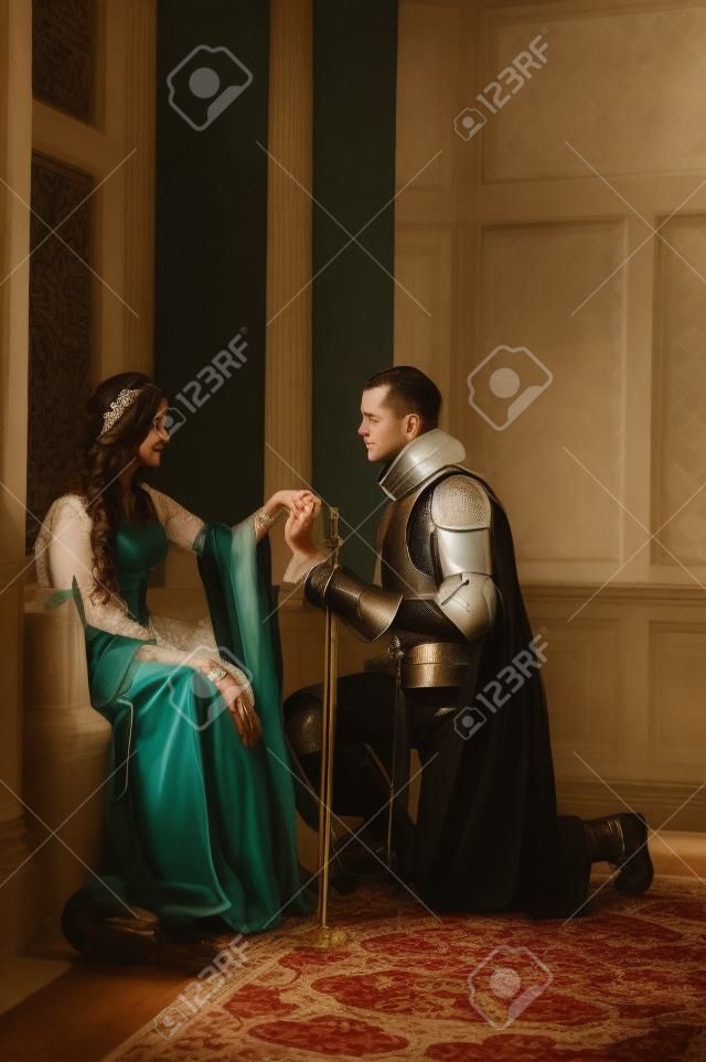 Un jeune chevalier se met à genoux devant sa dame son v?u d'engagement prononcer.