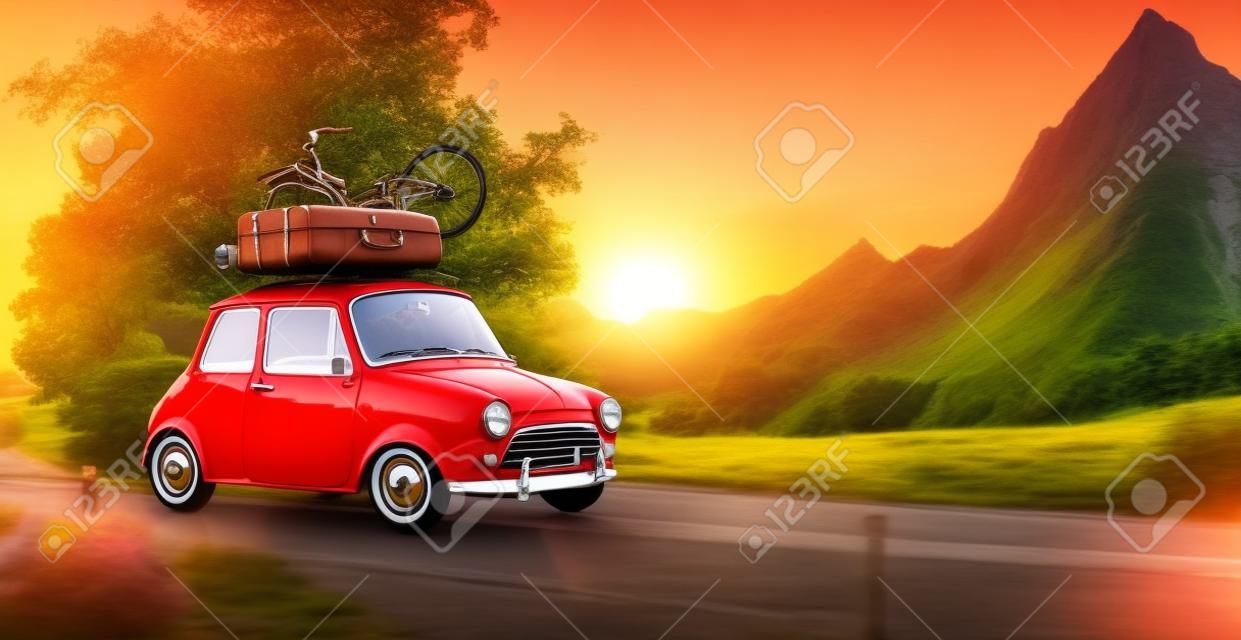 Mignon petite voiture rétro avec des valises et des bicyclettes sur le dessus passe merveilleuse route de campagne au coucher du soleil