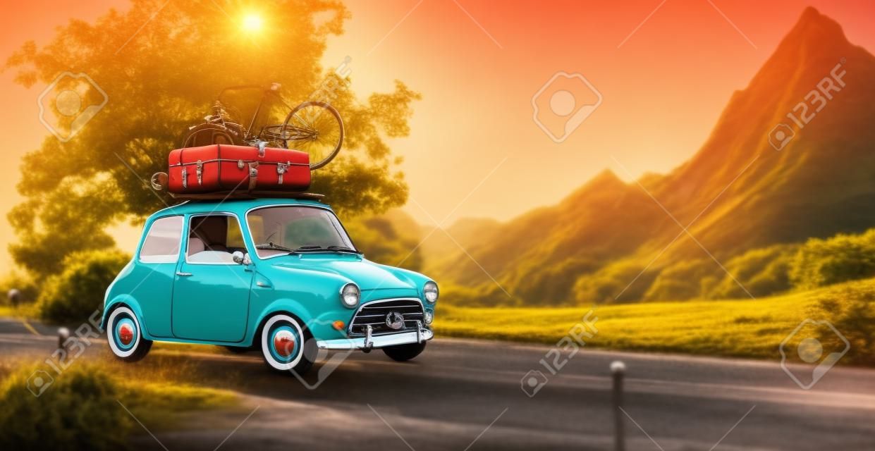 Симпатичные маленькие ретро автомобиль с чемоданами и велосипед на вершине идет прекрасной сельской дороге на закате