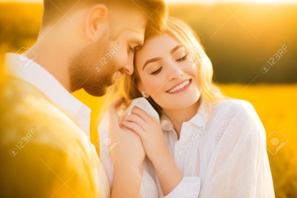 Image of young caucasian beautiful couple hugging together in golden field on countryside