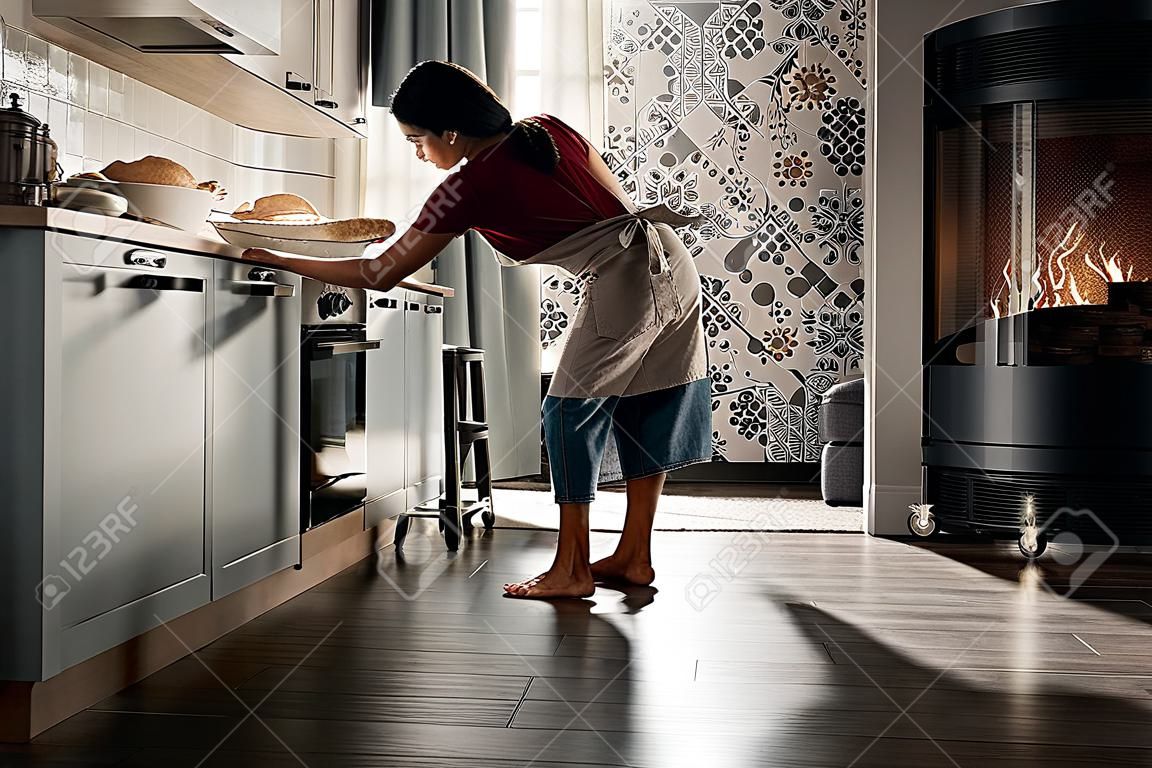 Jovem hispânico mulher vestindo avental cozinhar na cozinha em casa