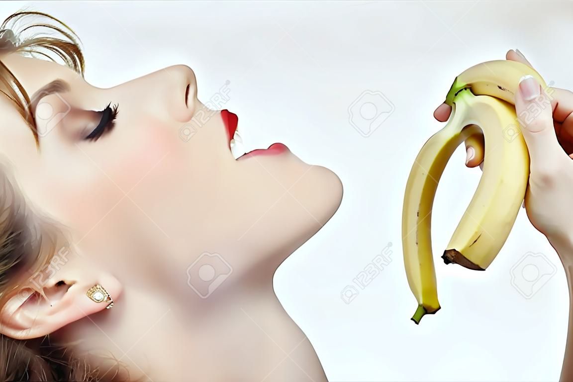 portret van een mooi meisje dat zich voorbereidt om een banaan af te bijten.