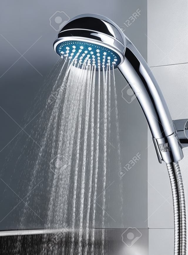 Silver shower head with flowing water in the bathroom