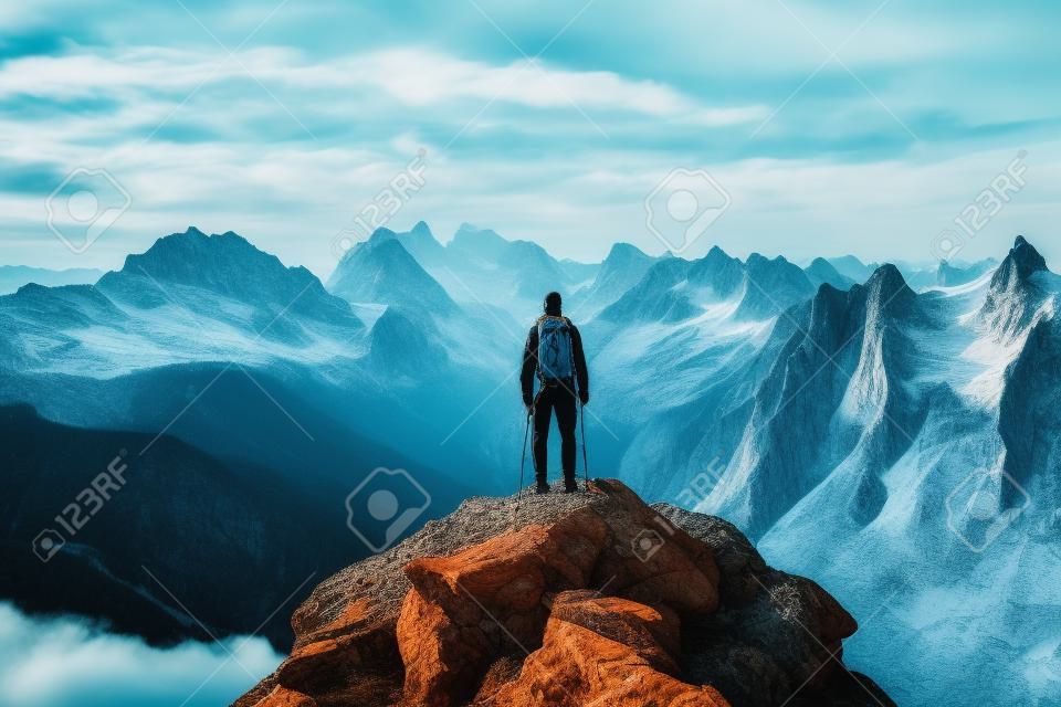 Homme debout au sommet de la montagne avec sac à dos sur le dos. IA générative.