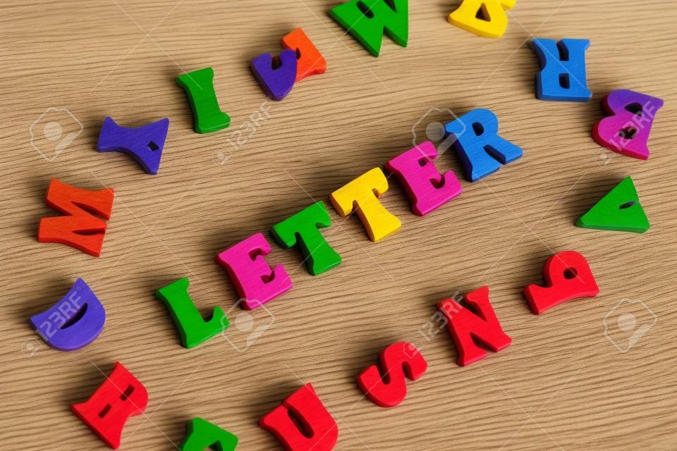 나무 글자로 만든 단어 LETTER. 단어 주위에 여러 가지 빛깔의 글자.