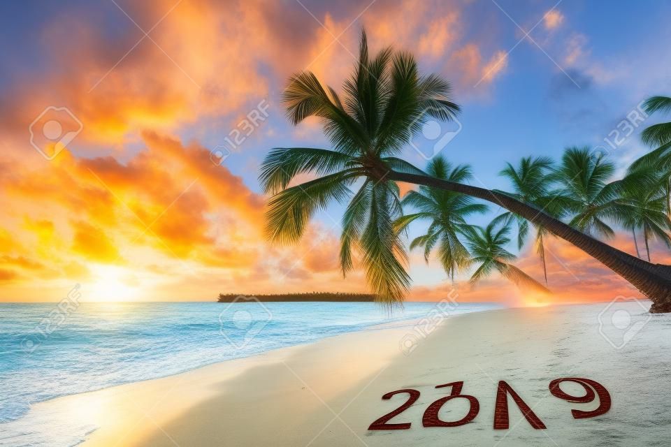 Szczęśliwego nowego roku 2019 koncepcja, napis na plaży. Wschód słońca nad morzem. Punta Cana
