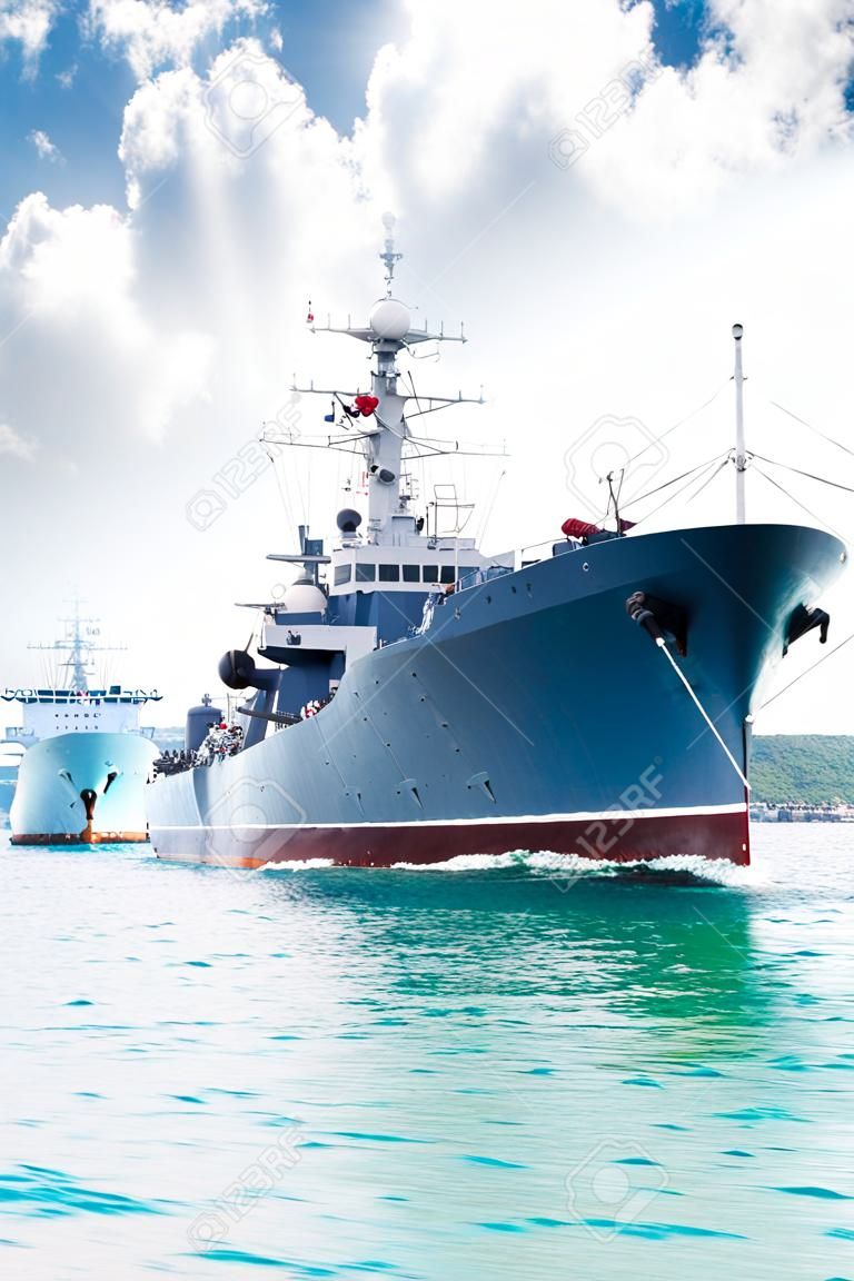 Military navy ship in the bay against blue sky