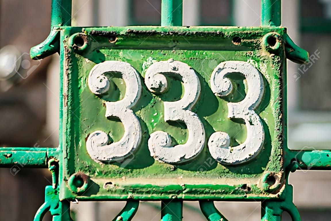 Old retro weathered cast iron plate with number 33 closeup