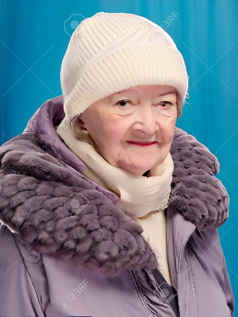 青の背景に winterclothing の笑顔の老婦人の肖像