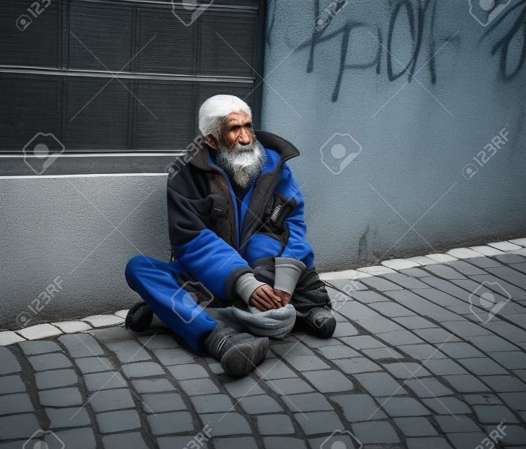 Бездомный на улице города. Старший нищий