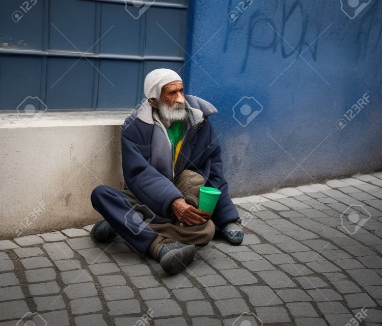 Homem sem-abrigo na rua da cidade. Idoso mendigo
