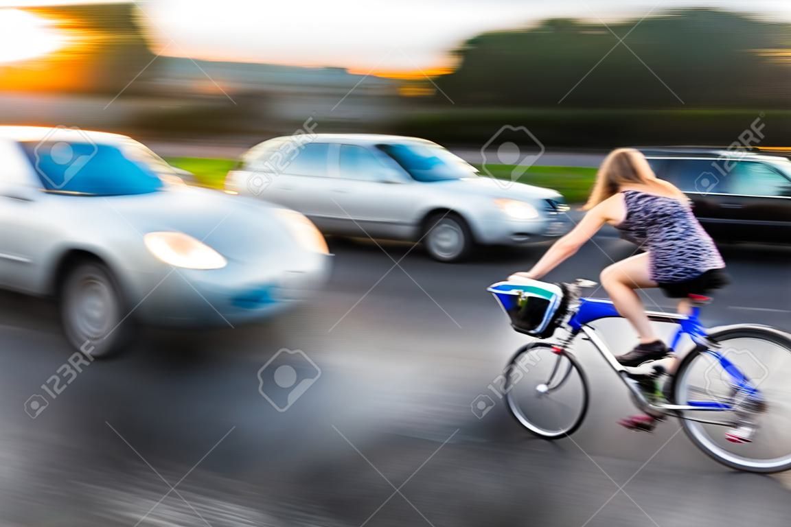Dangerous city traffic situation with cyclist and car in the city in motion blur
