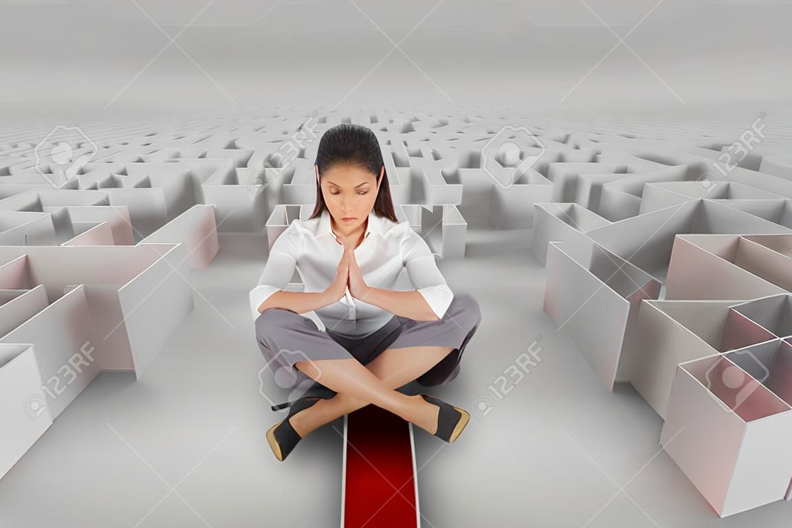 Digital composite of Woman sitting on a 3d maze with an arrow