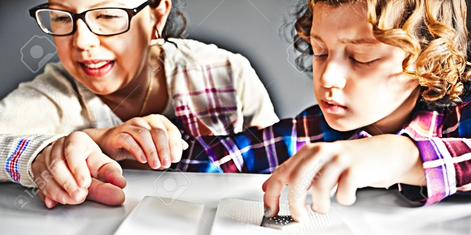 Leraar kijken naar jongen met behulp van Braille om te lezen op school