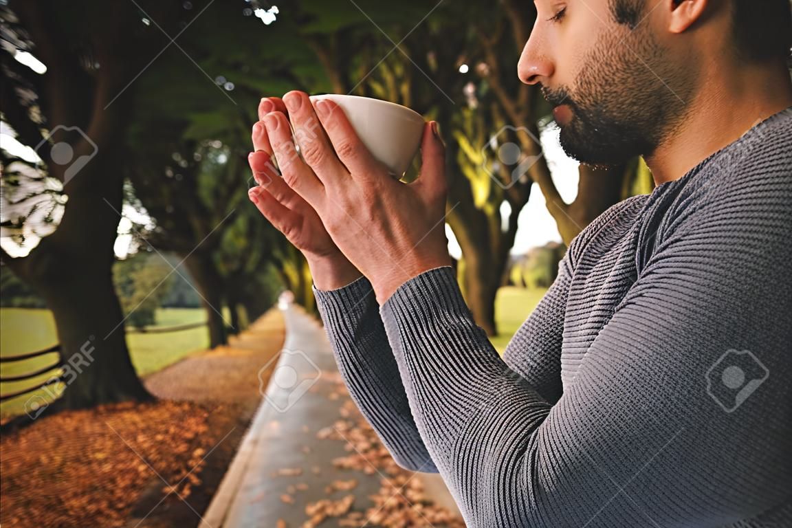 vue de côté de l & # 39 ; homme pensif ayant café contre le désert se reflétant au parc