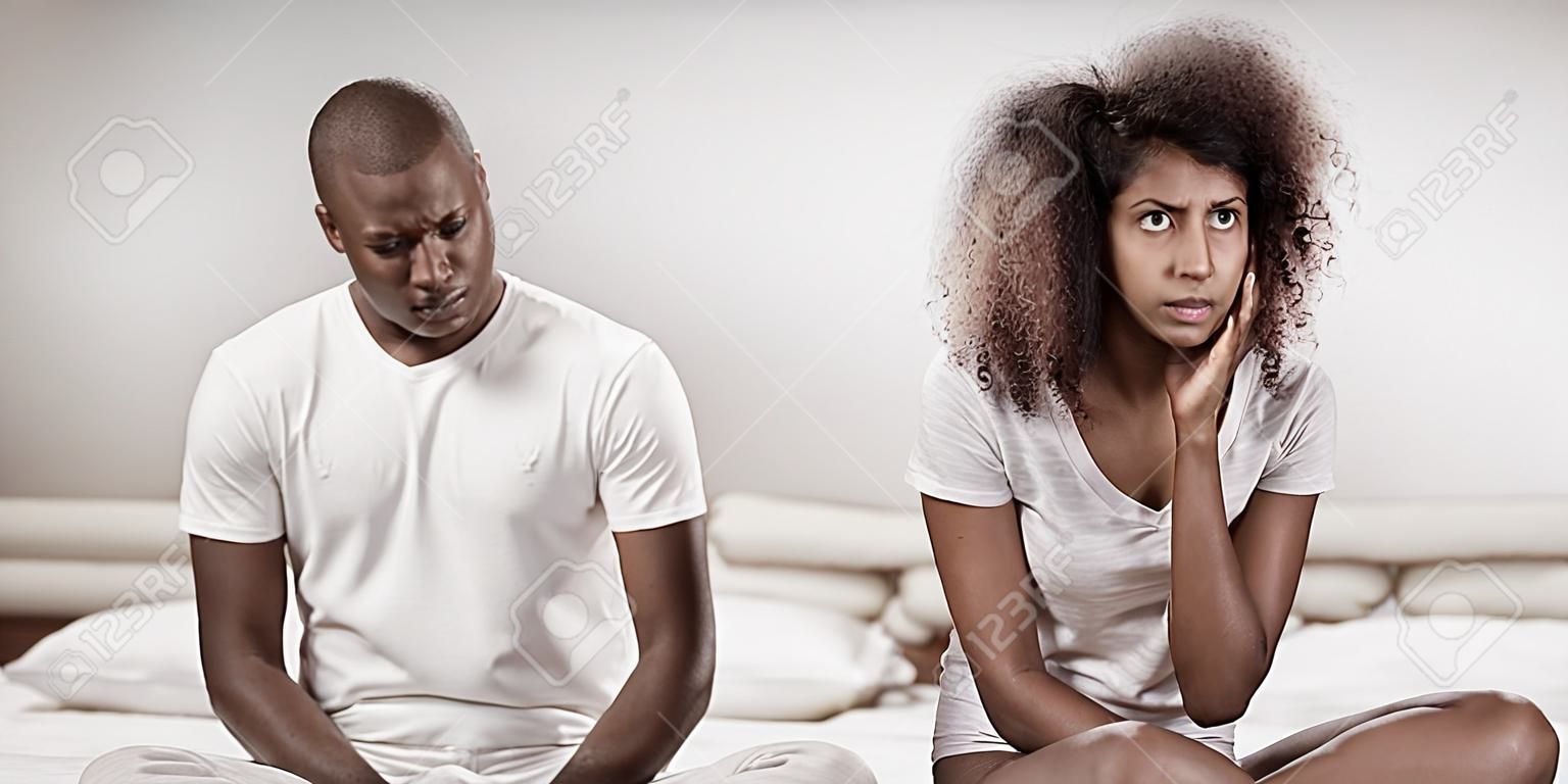 Zdenerwowana para ignorująca się nawzajem po kłótni na łóżku w sypialni