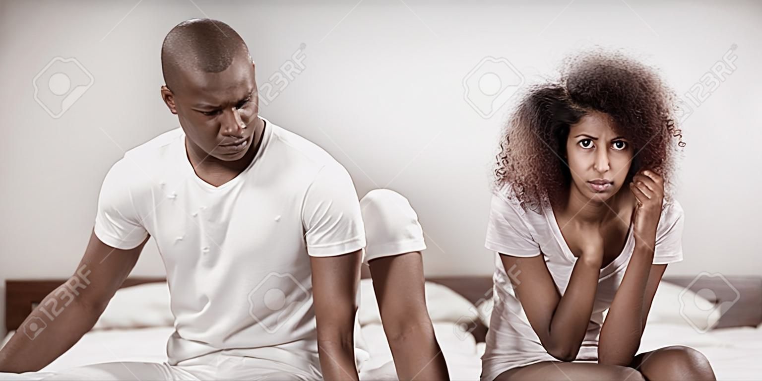 Casal perturbado ignorando um ao outro após briga na cama no quarto